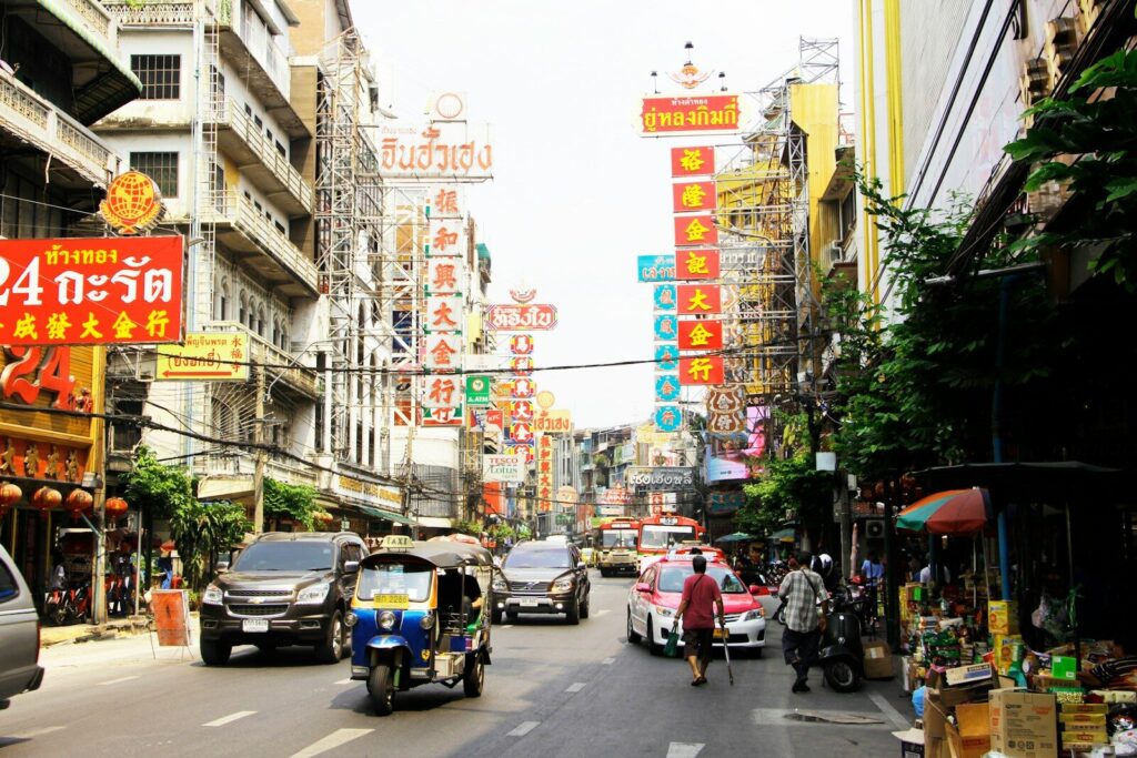 Folk og biler på gade i Bangkok