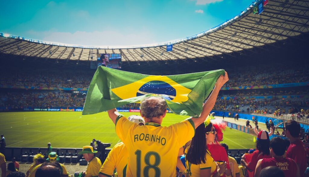 Brasiliansk fan holder flag oppe i et stadium til VM i fodbold